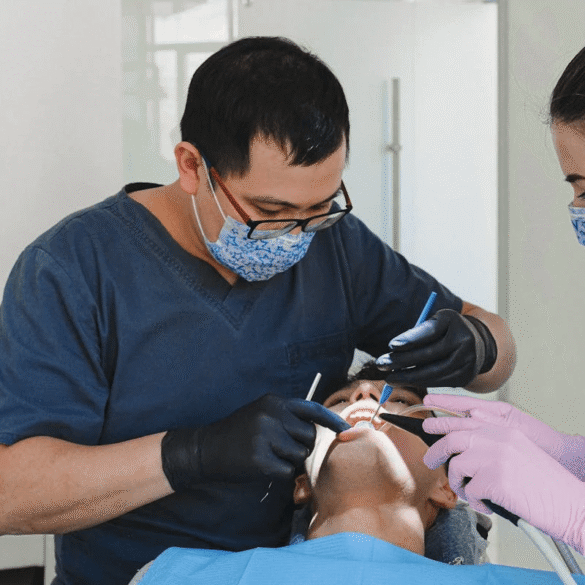 Dentist and dental nurse with patient in dentist chair